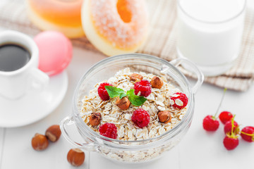 Oatmeal muesli with coffee and doughnuts on table. Healthy breakfast.