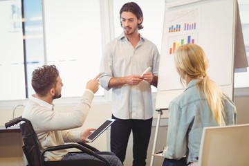 Obraz premium Disabled businessman pointing towards whiteboard