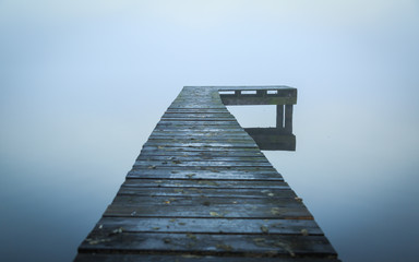 Close up of old, wooden jetty in the autumn fog.