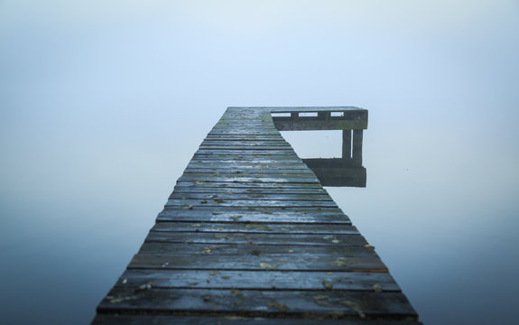 Close up of old, wooden jetty in the autumn fog.