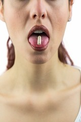 Woman with pill in mouth