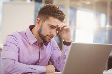 Worried businessman looking at laptop