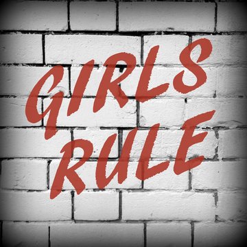 The words Girls Rule in red text on a brick wall background processed in black and white for effect