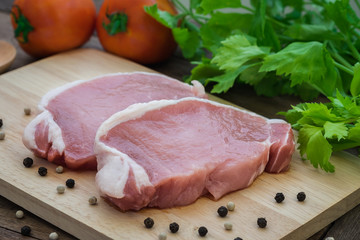 Raw pork meat sliced on wooden cutting board