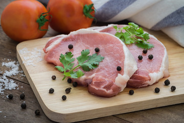 Raw pork meat sliced on wooden cutting board