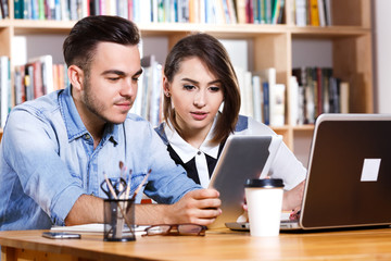 Obraz premium Young business woman and man sitting at the table