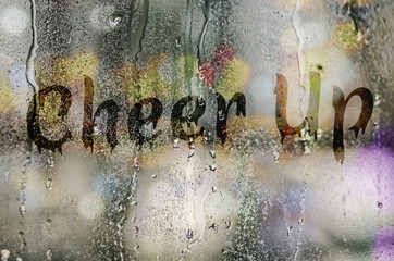 natural water drops on glass window with the text "Cheer Up"