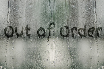 natural water drops on glass window with the text "out of order"