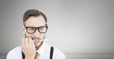 Composite image of geeky hipster biting on pencil