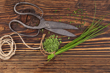 Fresh and dry chives on wooden table.