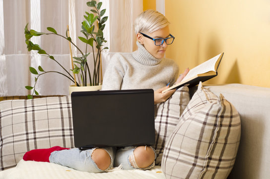 Young beautiful hipster woman, reading a book instead of using computer