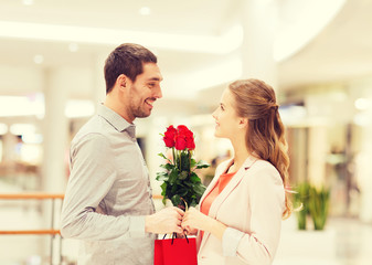 happy young couple with flowers in mall