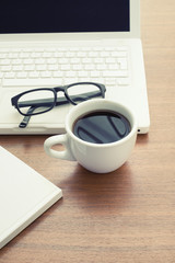 Coffee cup and laptop at office