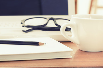 Coffee cup and laptop at office
