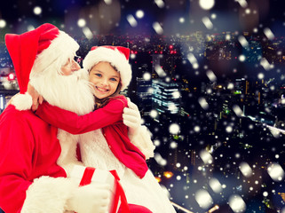 Fototapeta na wymiar smiling little girl with santa claus and gifts