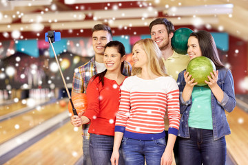 happy friends taking selfie in bowling club