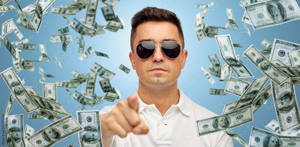 Wall mural man pointing on you with falling dollar money