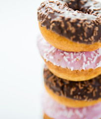 close up of glazed donuts pile over white