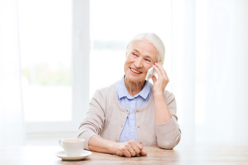 senior woman with smartphone calling at home