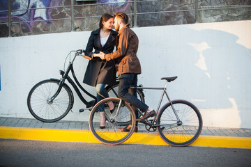 Plakat Young couple with a bicycle opposite city 