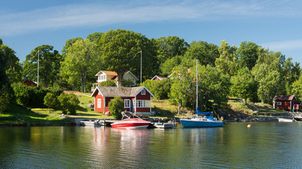 Schwedenhäuser und Boote auf Schäreninsel im Archipelago