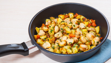 Fried potato with mushrooms in a frying pan