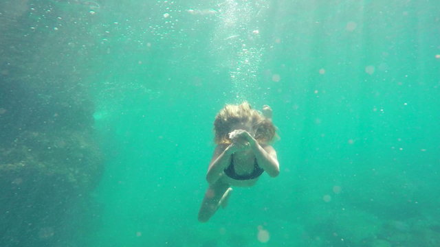 Woman Swimming Underwater In Slow Motion. Swimming Towards Camera by Coral Reef in Ocean in Hawaii. Young Attractive Beautiful Woman Mermaid.