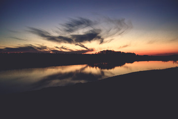 Dicey ducks floating on the lake at sunset in autumn