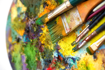 Fototapeta premium Paint brushes, painting palette with colors on white background