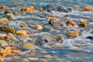 Pebble stones in the river water close up view,
