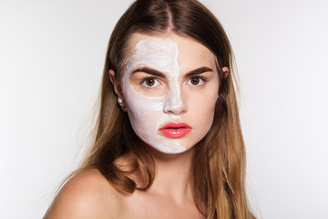 Beauty girl getting clay facial mask, spa concept