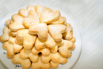 plate with butter cookies with sugar heart shapes. copy space for your text.