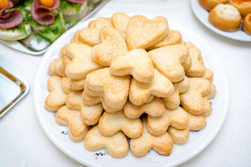 plate with butter cookies with sugar heart shapes.