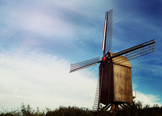 old windmill made of bricks against blue sky