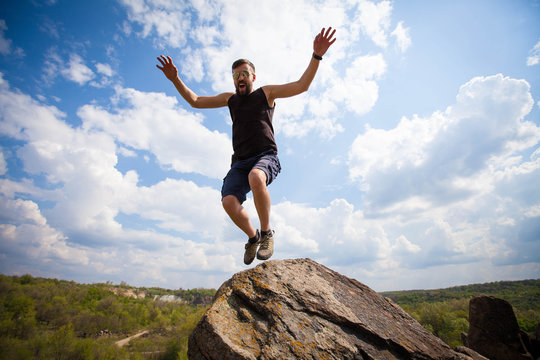 Young man jumps from the top of the rock