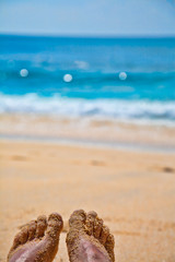 Fototapeta na wymiar Feet on a sand beach