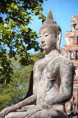 Stone Buddha statue seated in the lotus position at Wat Mahathat, Ayutthaya, Thailand