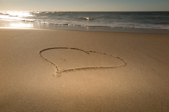 Beautiful heart in sand at the beach - love symbol