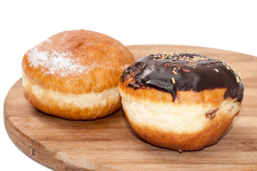 Donuts with chocolate and vanilla on the wooden board