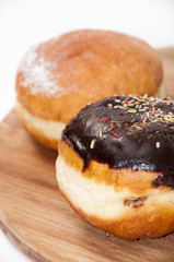 Donuts with chocolate and vanilla on the wooden board