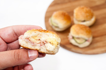Hand holding hamburger sandwiches