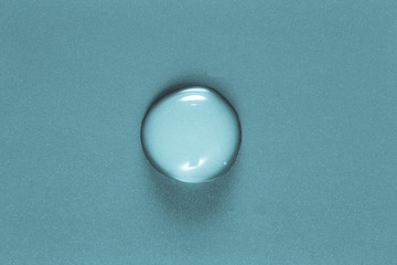 One big drop of water on a color background. Shallow depth of fi