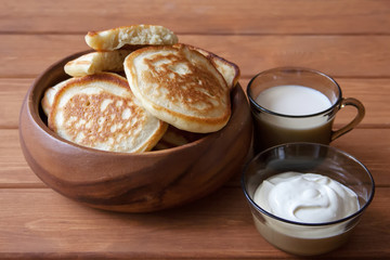 Fried fritters on plate with sour cream and milk