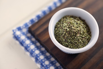 Dried Oregano.High angle view of white bowl full of dried oregano. Very shallow depth of field.