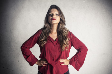 Beautiful young girl posing on a wall background