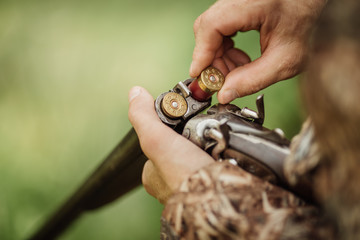 hunter in camouflage clothes ready to hunt with hunting rifle