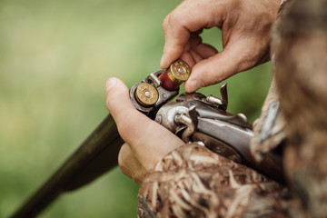 hunter in camouflage clothes ready to hunt with hunting rifle