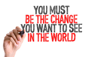 Hand with marker writing: You Must Be The Change You Want to See in the World