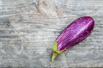 Purple eggplant on the old wooden board