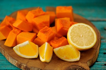 Sweet pumpkin, orange and lemon cut on wooden board